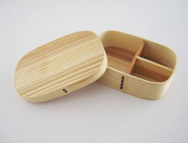 An open wooden lunch box with 3 compartments