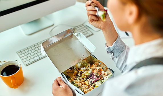 Person healthy meal using paper box while working in the office