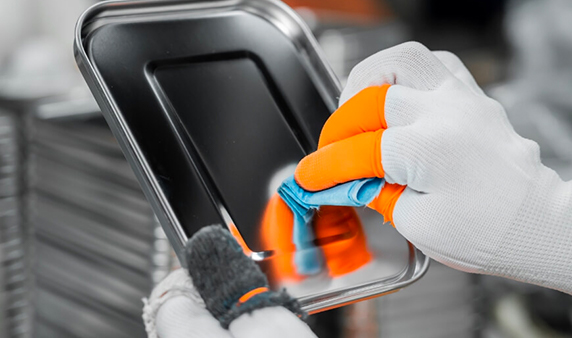 Person wiping the stainless steel lunch box lid