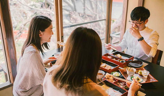 Three person eating in restaurant using Japanese bento boxes