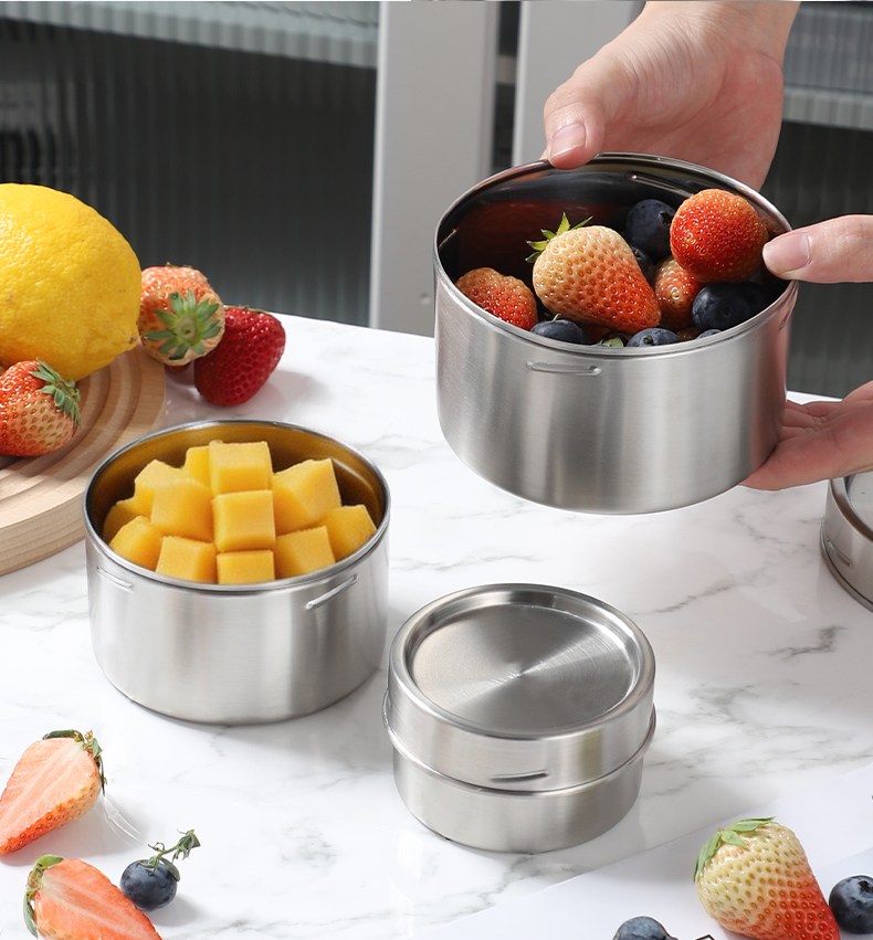 Stainless steel containers filled with fresh strawberries blueberries and mango cubes — healthy meal prep